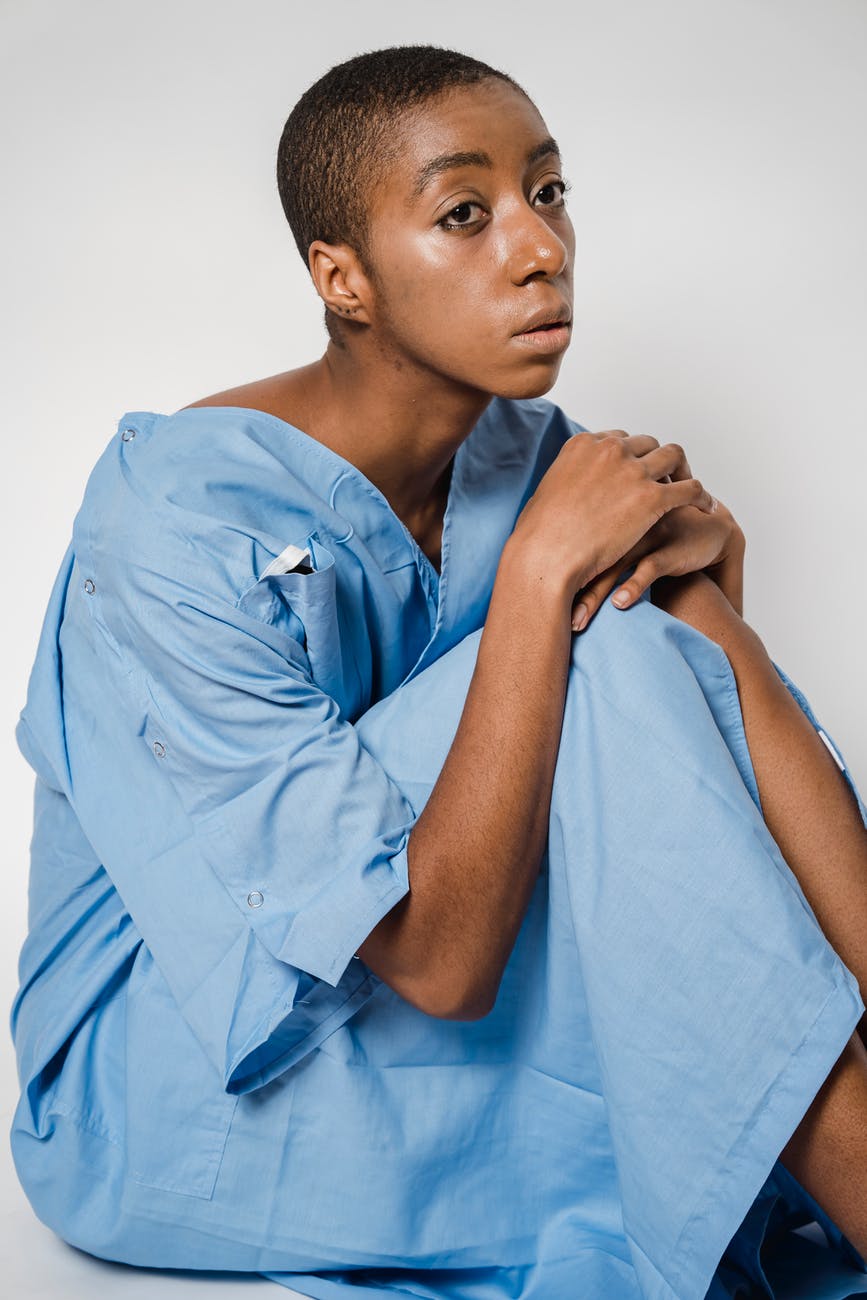pensive black woman in medical uniform of patient