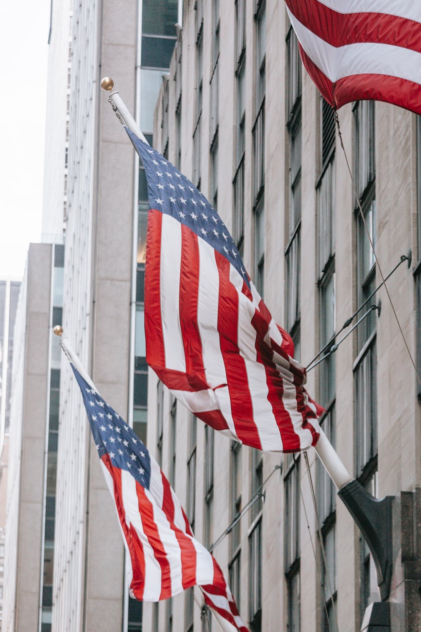 usa flags on wall of governmental building facade in city